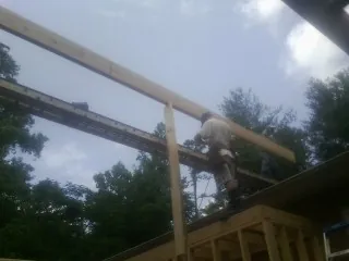 Carpenter setting a ridge beam over a new addition frame — Ice Dam Removal by Roofing Brothers in Marion Station