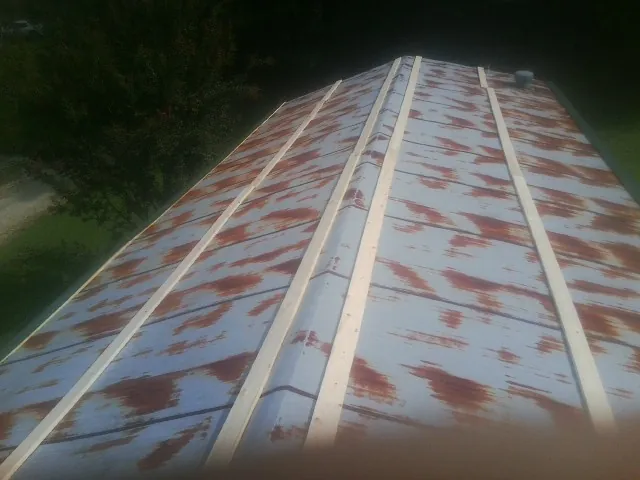 Rusted metal roof panels with new wood purlins before replacement — Storm Damage Roof Repair in Marion Station by Roofing Brothers