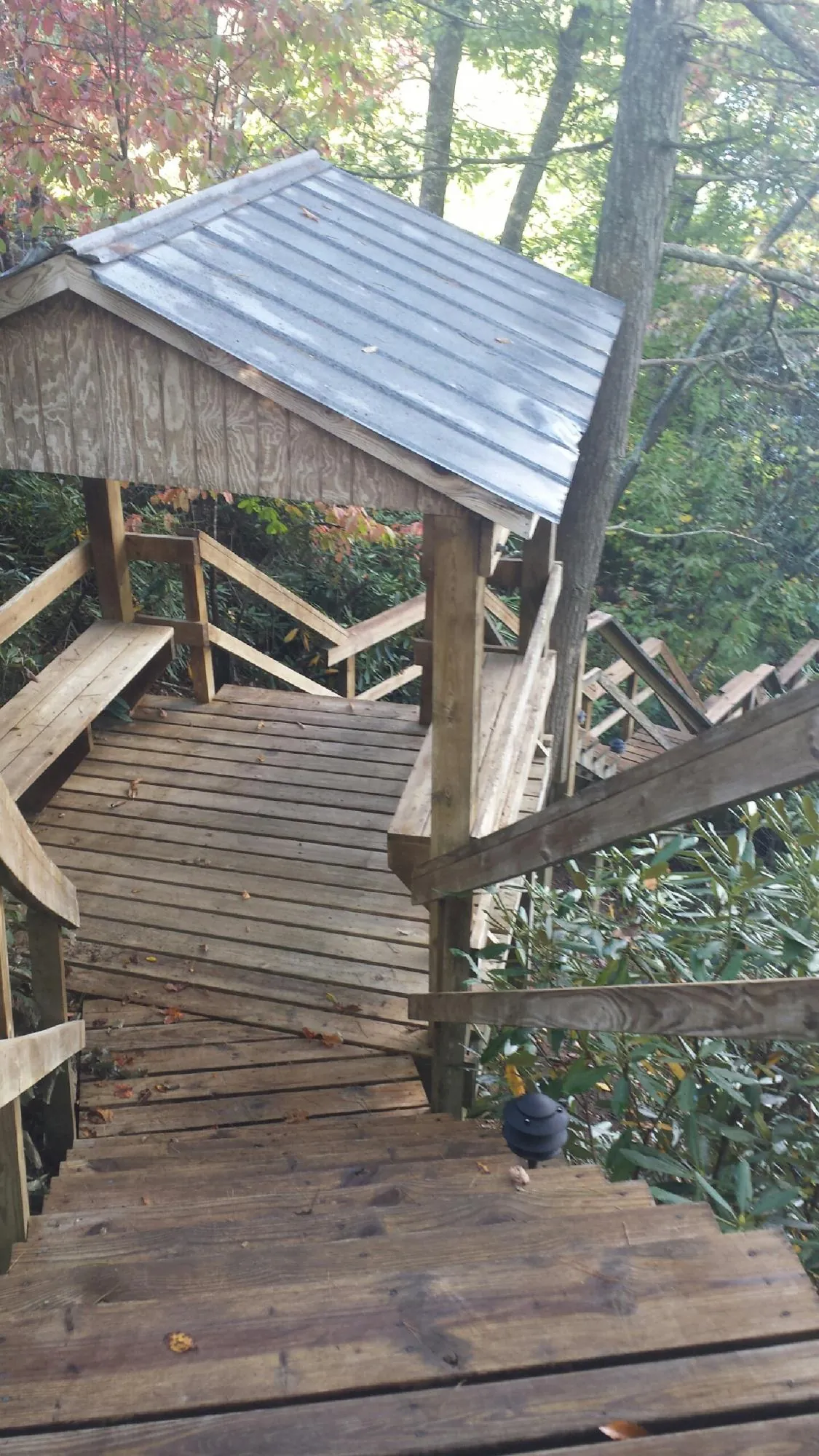 Metal roofed shelter over wooden steps on a wooded walkway — Skylight Repair & Installation work by our crew in Marion Station