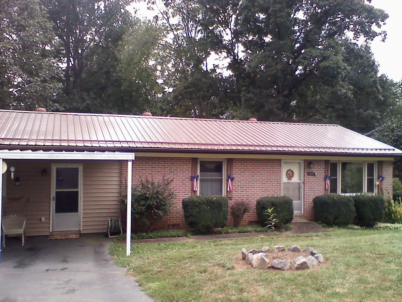 Bronze metal roof and carport on a brick ranch home — Roof Repair work by our crew in Marion Station