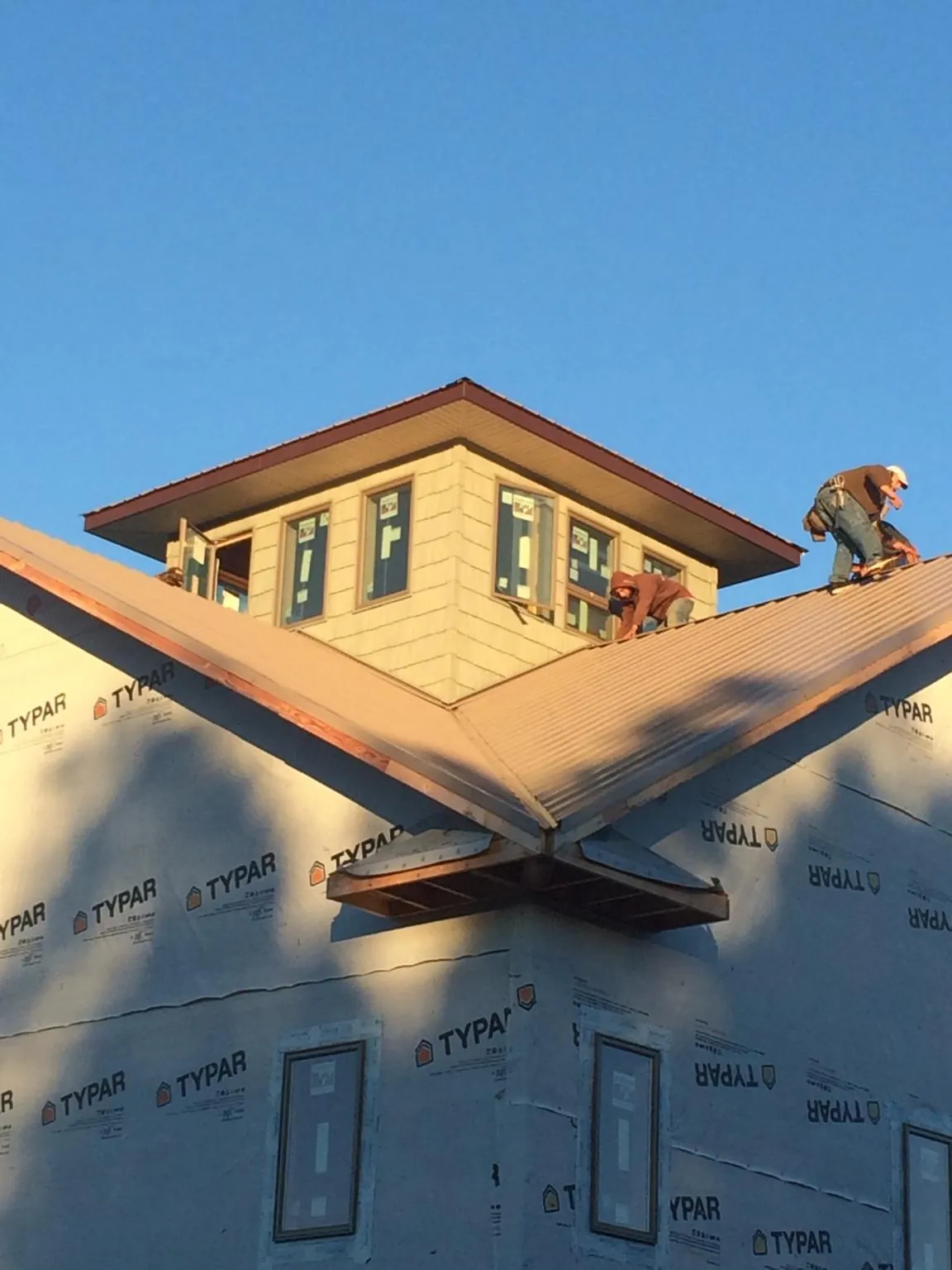 Roofers working around a rooftop cupola on a new metal roof at sunset — Roof Waterproofing in Marion Station by Roofing Brothers